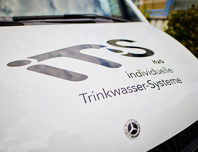 Individuelle Trinkwasser-Systeme - Firmenlogo auf der Motorhaube des Firmenwagens Firmenlogo auf der Motorhaube des Firmenwagens
